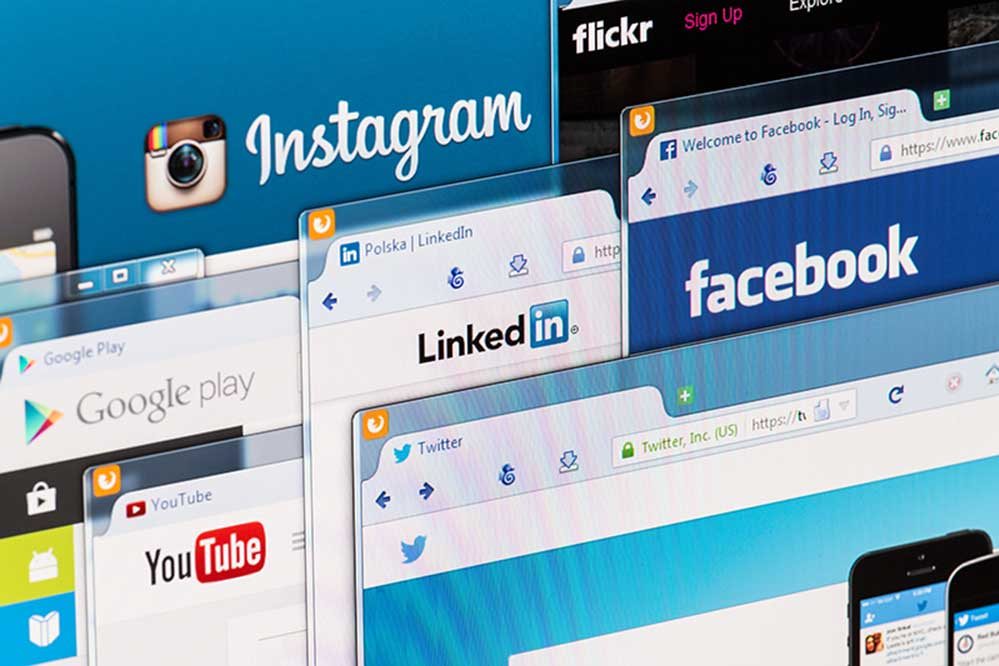 Bildschirme mit Instagram, Facebook, LinkedIn und YouTube